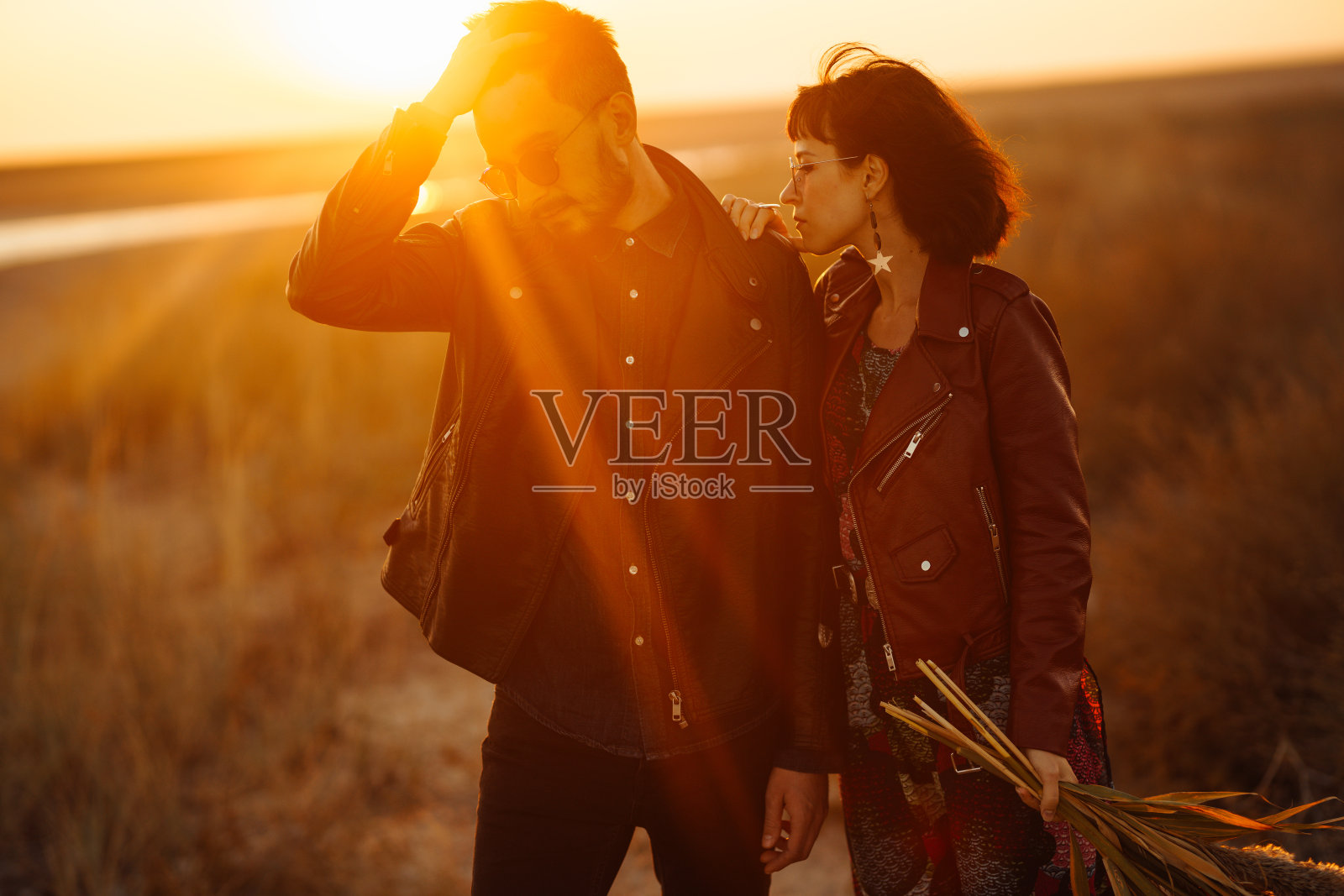 时尚恩爱的情侣在日落时分的海边享受彼此照片摄影图片