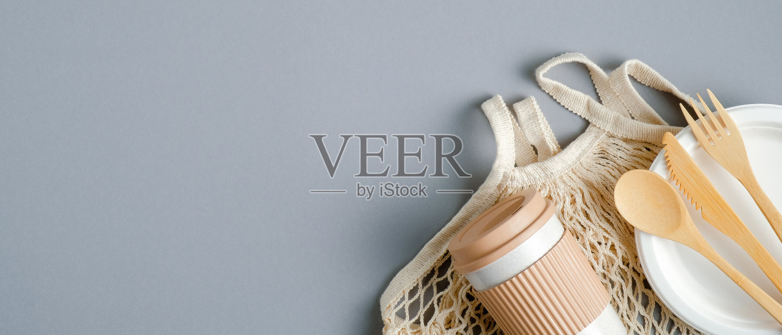 可重复使用的网袋，环保的木制餐具和竹咖啡杯在灰色的背景。生态商店横幅设计与复制空间。俯视图，平放照片摄影图片
