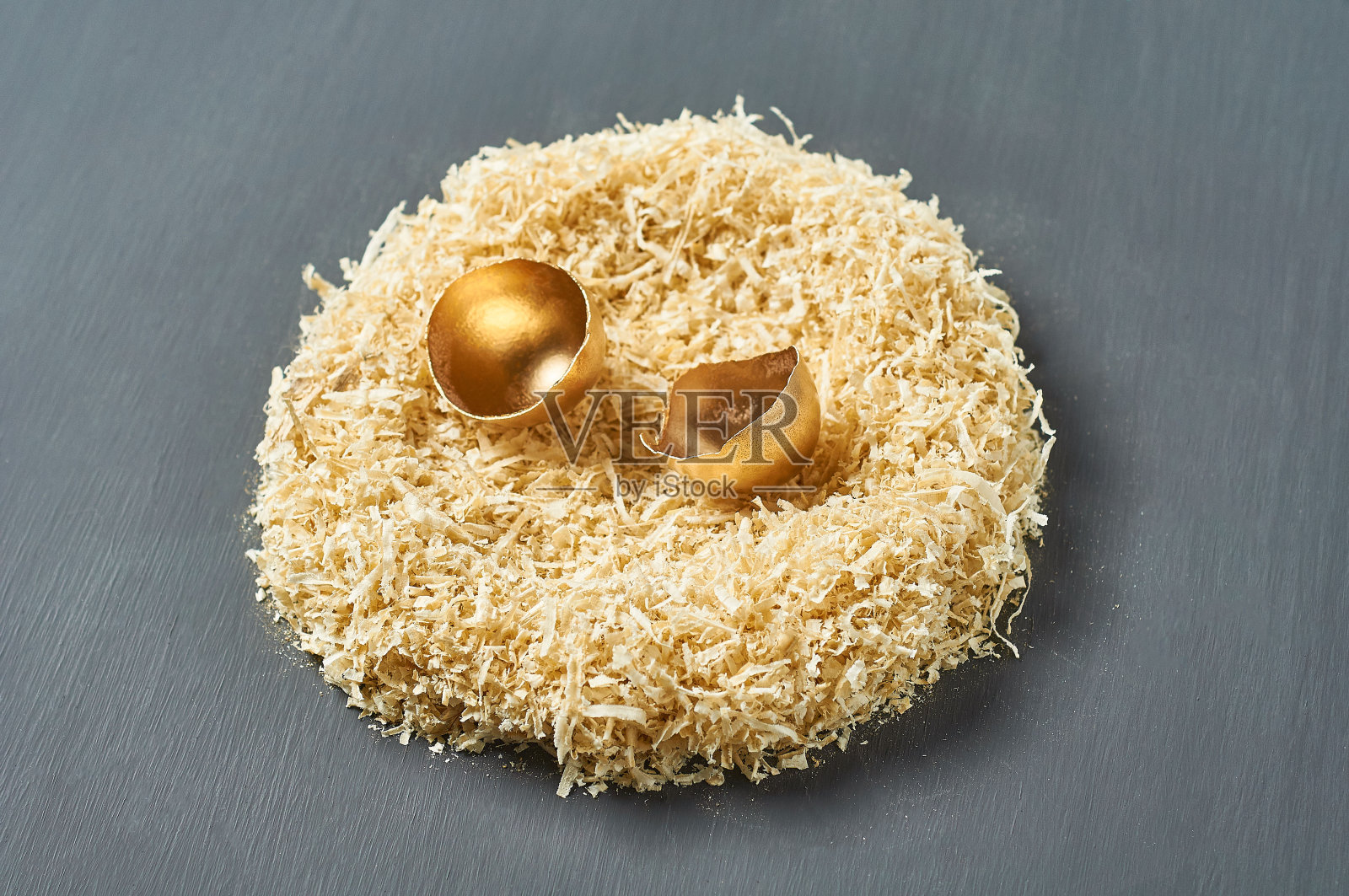 在黑色的混凝土背景下，鸟蛋上涂着金色的壳。复活节的概念。成功商业和投资的象征照片摄影图片