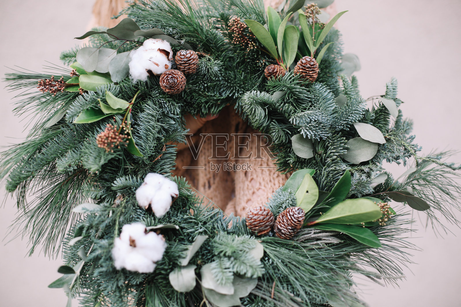 圣诞装饰品。圣诞花环。花商制作圣诞花环。观女性手捧花圈。照片摄影图片