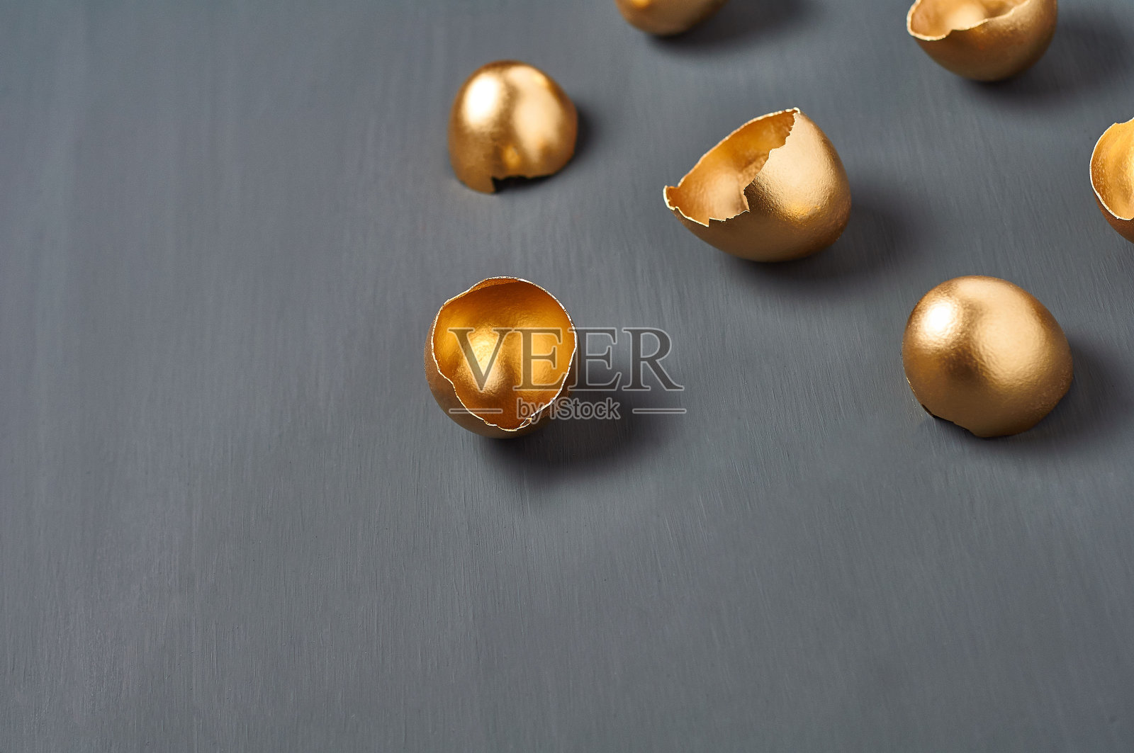 黑色混凝土背景上的金色蛋壳。复活节的概念，无价的创意，成功的商业投资或奢华的早餐。本空间照片摄影图片