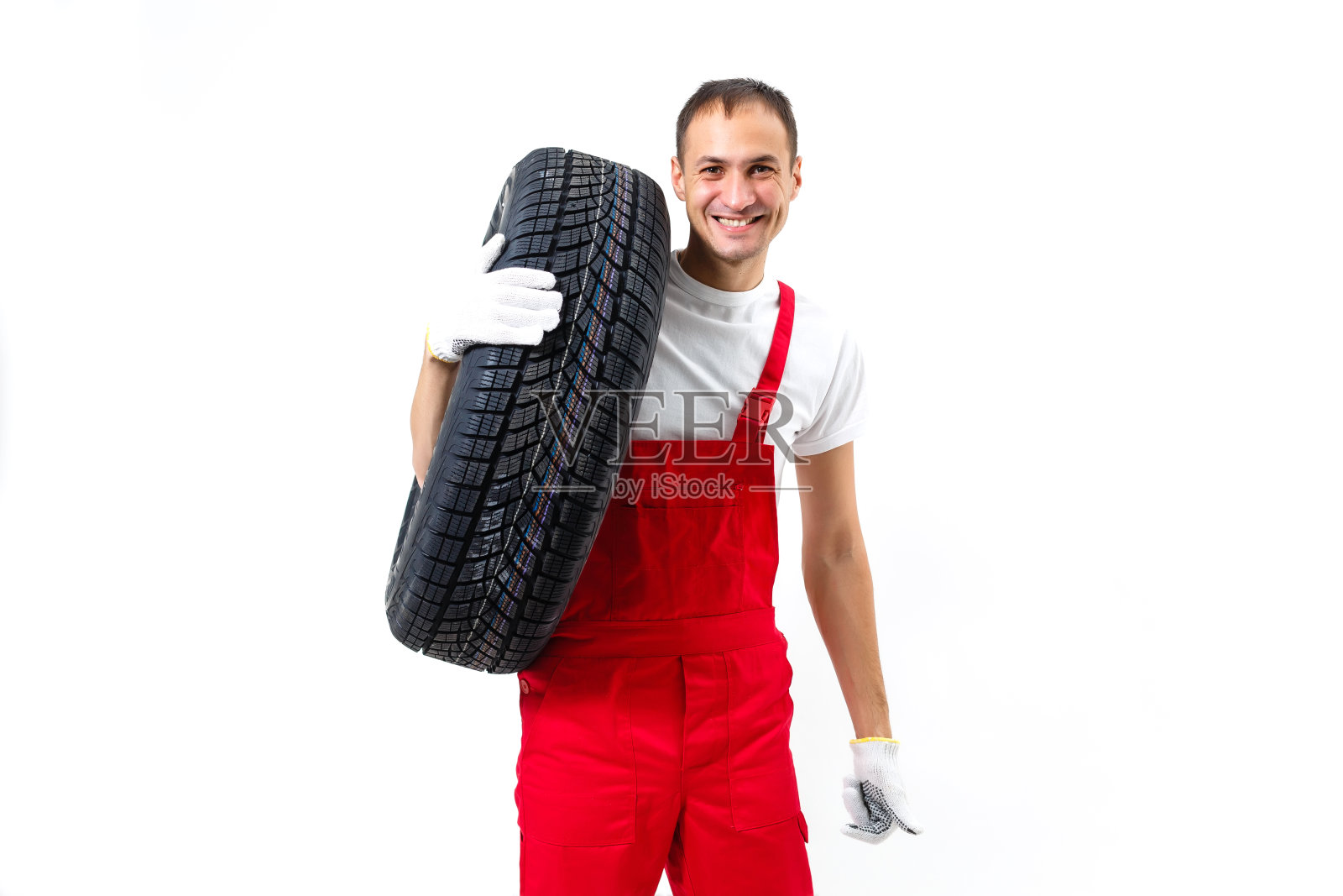 笑容满面的男修理工手持轮胎，白色背景照片摄影图片