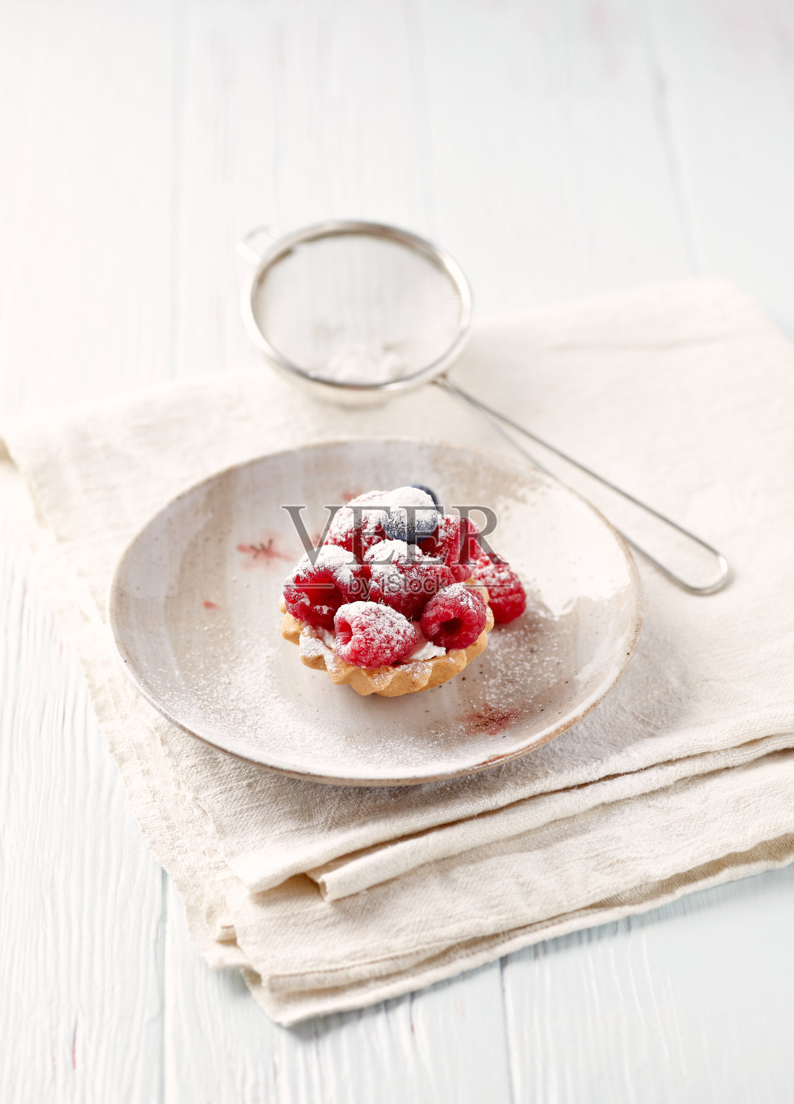 木质背景上点缀着新鲜覆盆子的马斯卡泊尼小馅饼。照片摄影图片