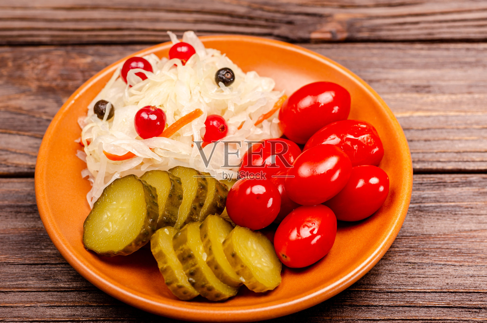 美味的自制腌菜碟上有泡菜、腌西红柿、泡菜、木雕背景。照片摄影图片