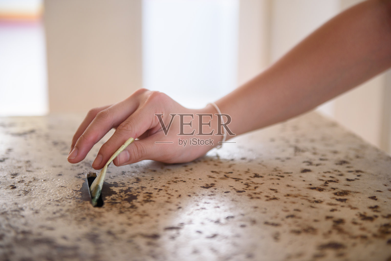 男子亲手将钱放入捐款箱照片摄影图片