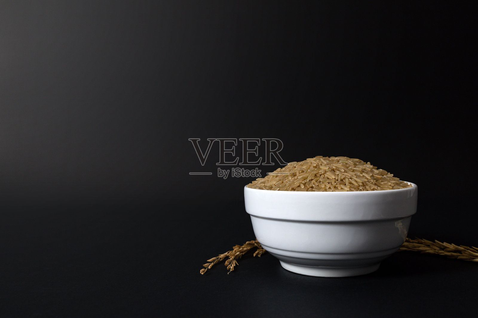 泰国煮百米糙米在白色陶瓷碗在黑色的背景。照片摄影图片