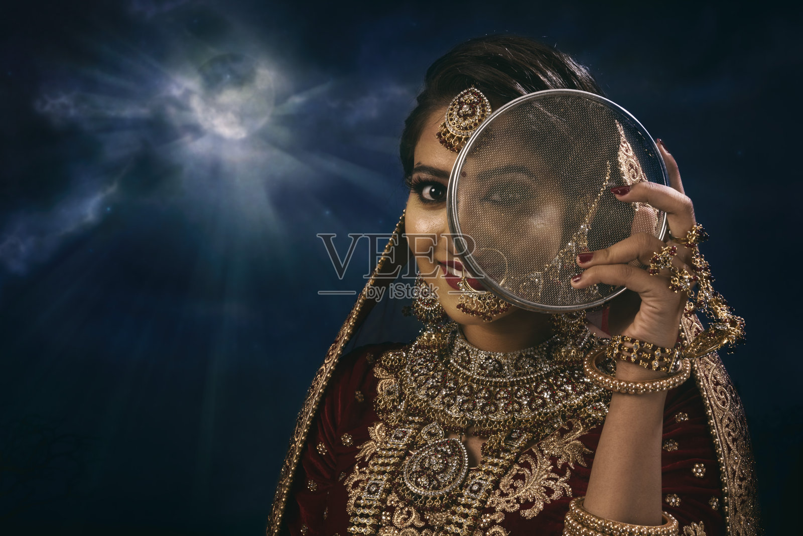 年轻的印度妇女穿着婚纱，戴着珠宝，化妆照片摄影图片