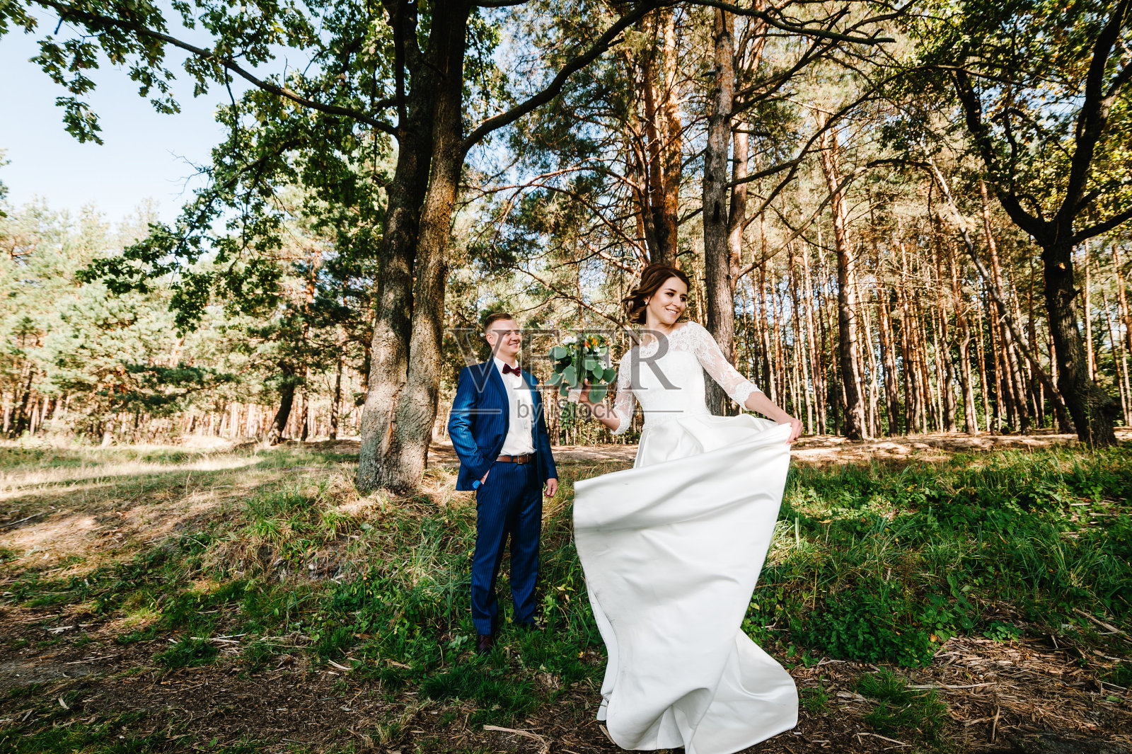 年轻的新娘和新郎在他们的婚礼上快乐。新婚夫妇-新家庭!婚礼花束。照片摄影图片