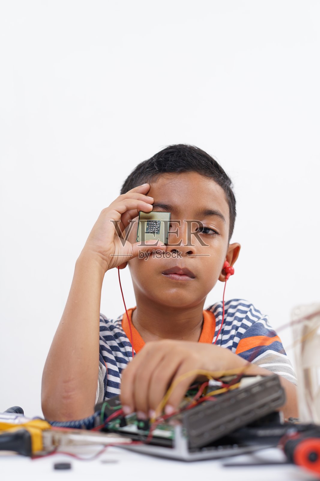 男孩拿着处理器来识别和修理电脑主板的问题照片摄影图片