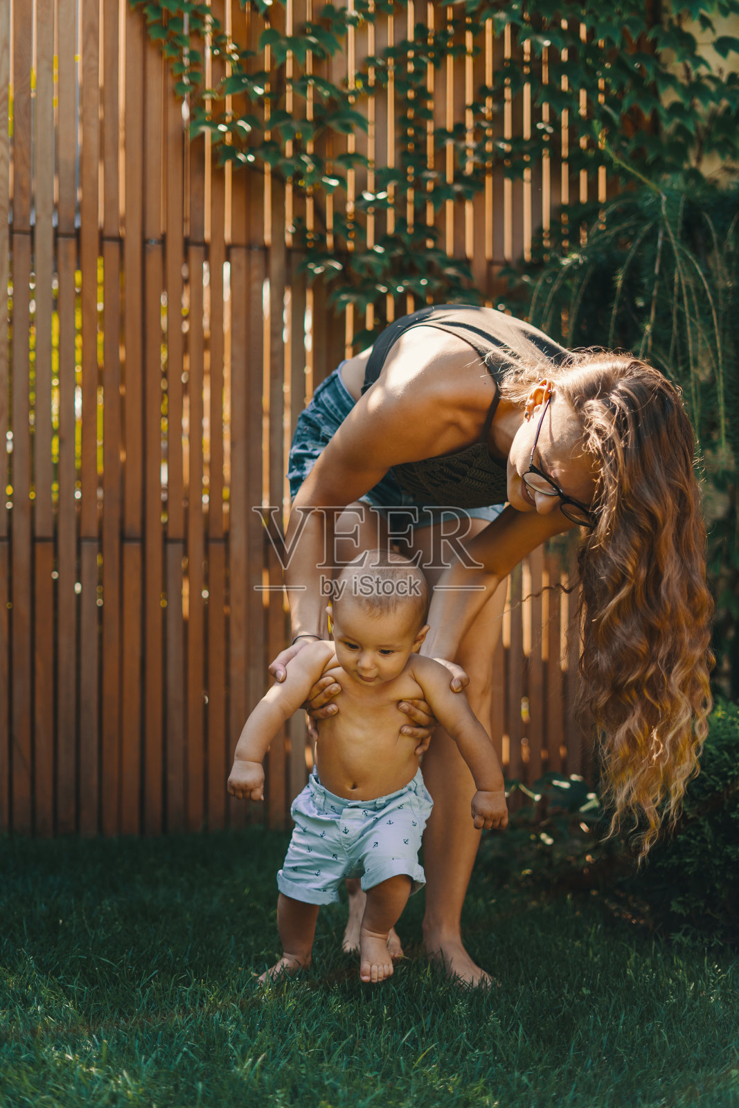 宝宝在后院的绿草地上迈出第一步照片摄影图片