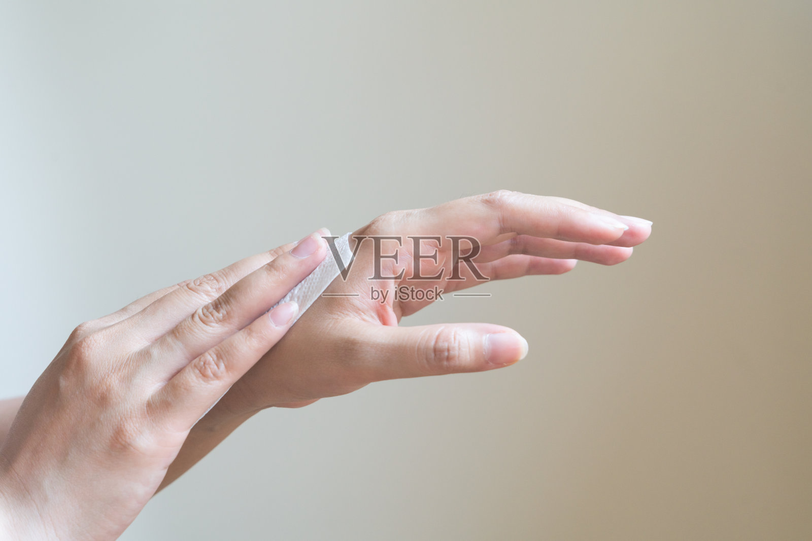 一个女人正在用白色的软纸巾擦手。孤立在白色背景上照片摄影图片