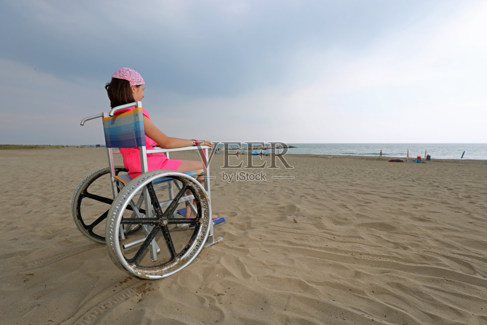 小女孩坐在特别的大轮子轮椅上照片摄影图片