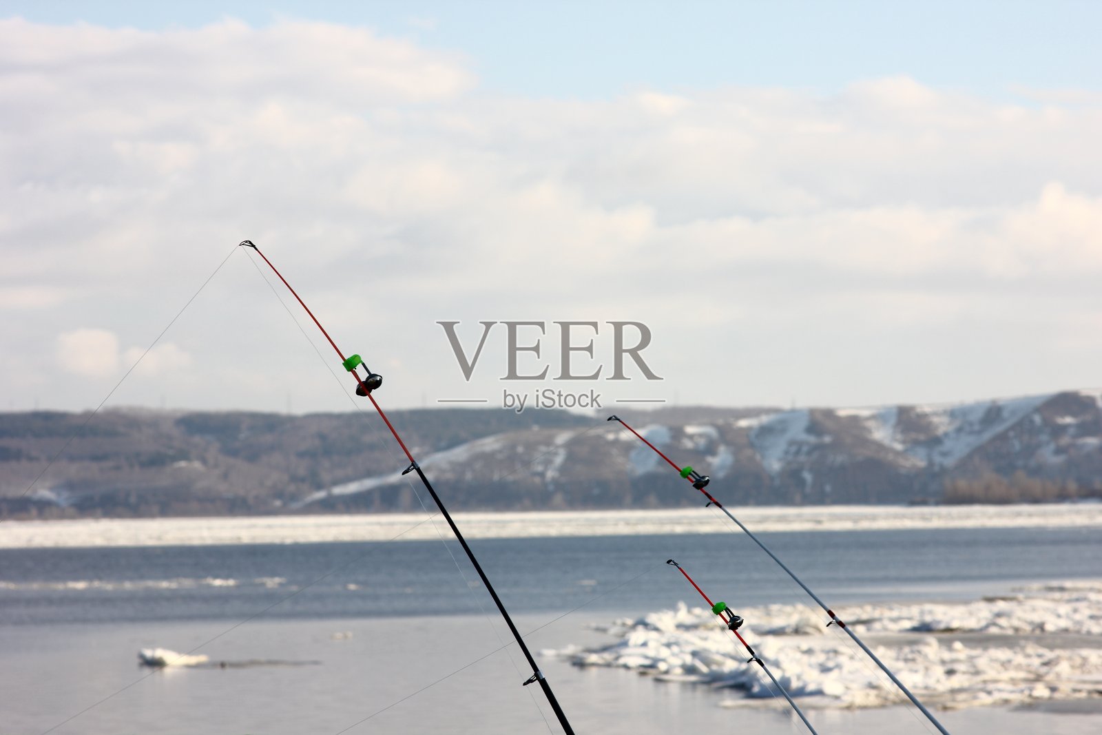 模糊的背景上的钓鱼设备与春天的河流浮动浮冰照片摄影图片