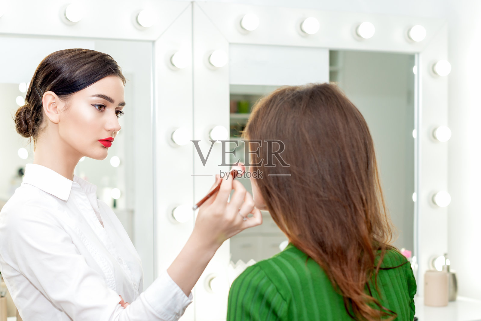 化妆师在搽粉。照片摄影图片