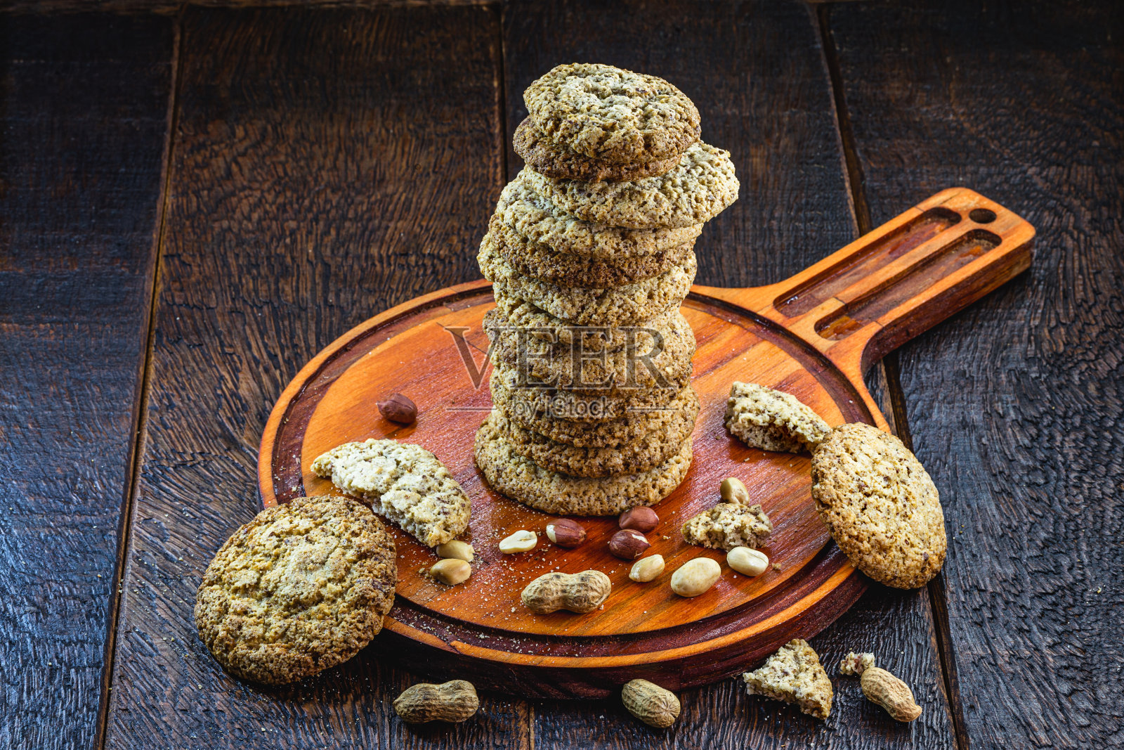 自制的花生饼干，堆放在质朴的杏仁桌上。健康的理念脱颖而出。照片摄影图片