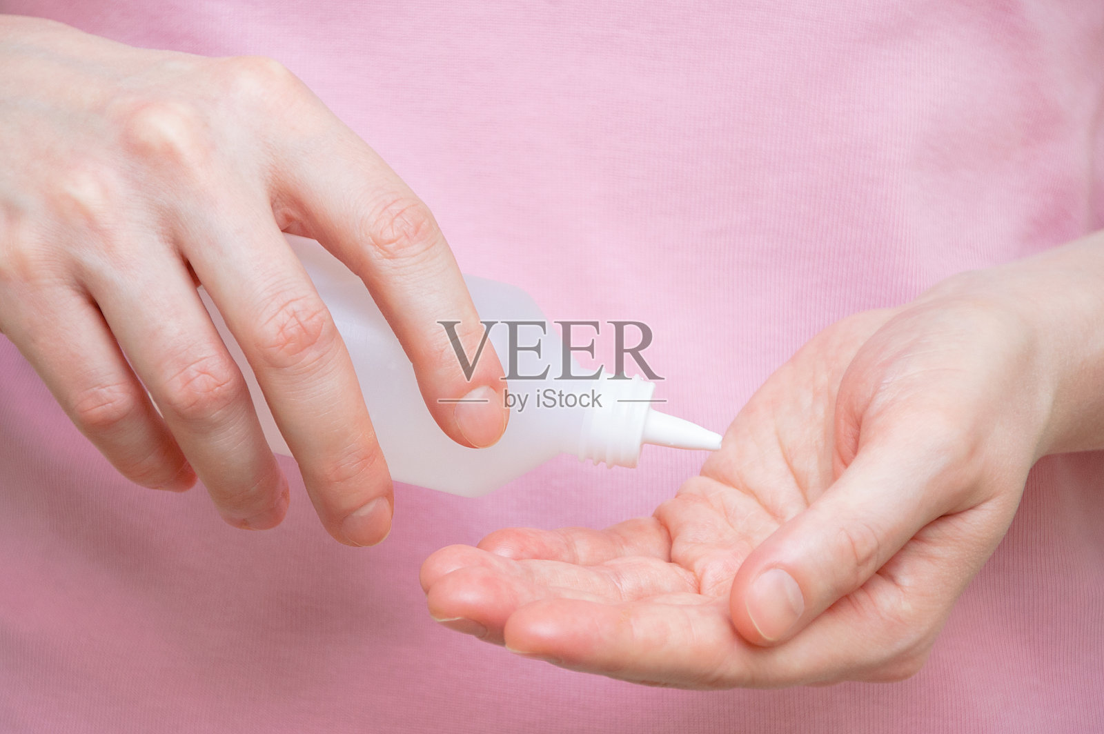 白种女人手上的杀菌剂。手部治疗细菌和病毒。照片摄影图片