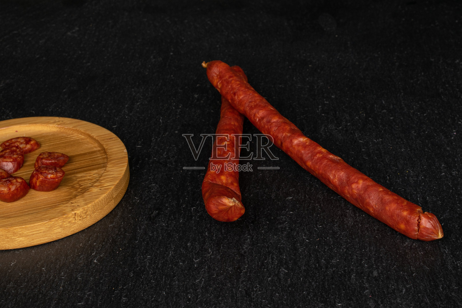 灰石头上的熏辣香肠照片摄影图片