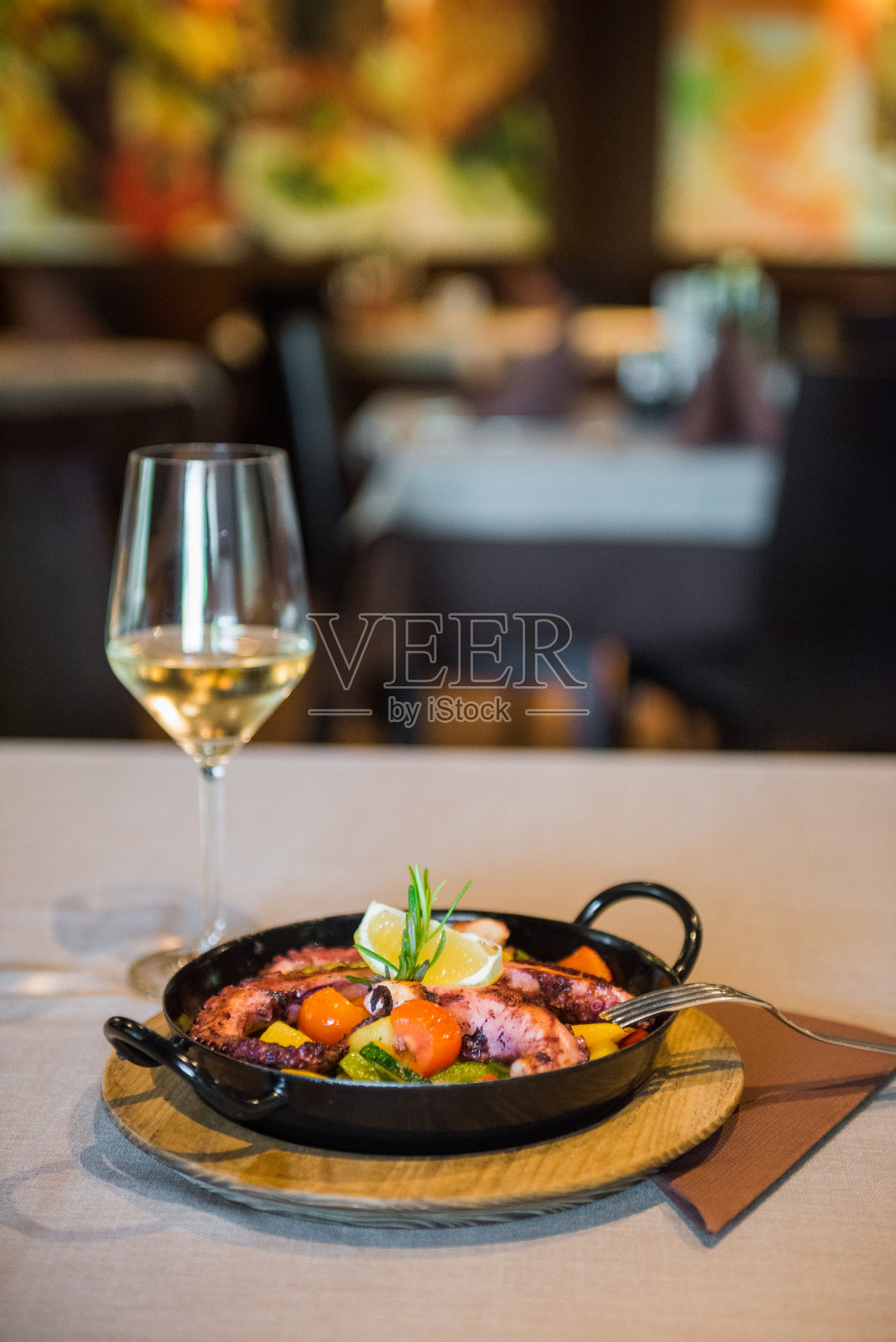 烤章鱼盘配新鲜蔬菜，用黑色铁制的平底锅烹制。照片摄影图片