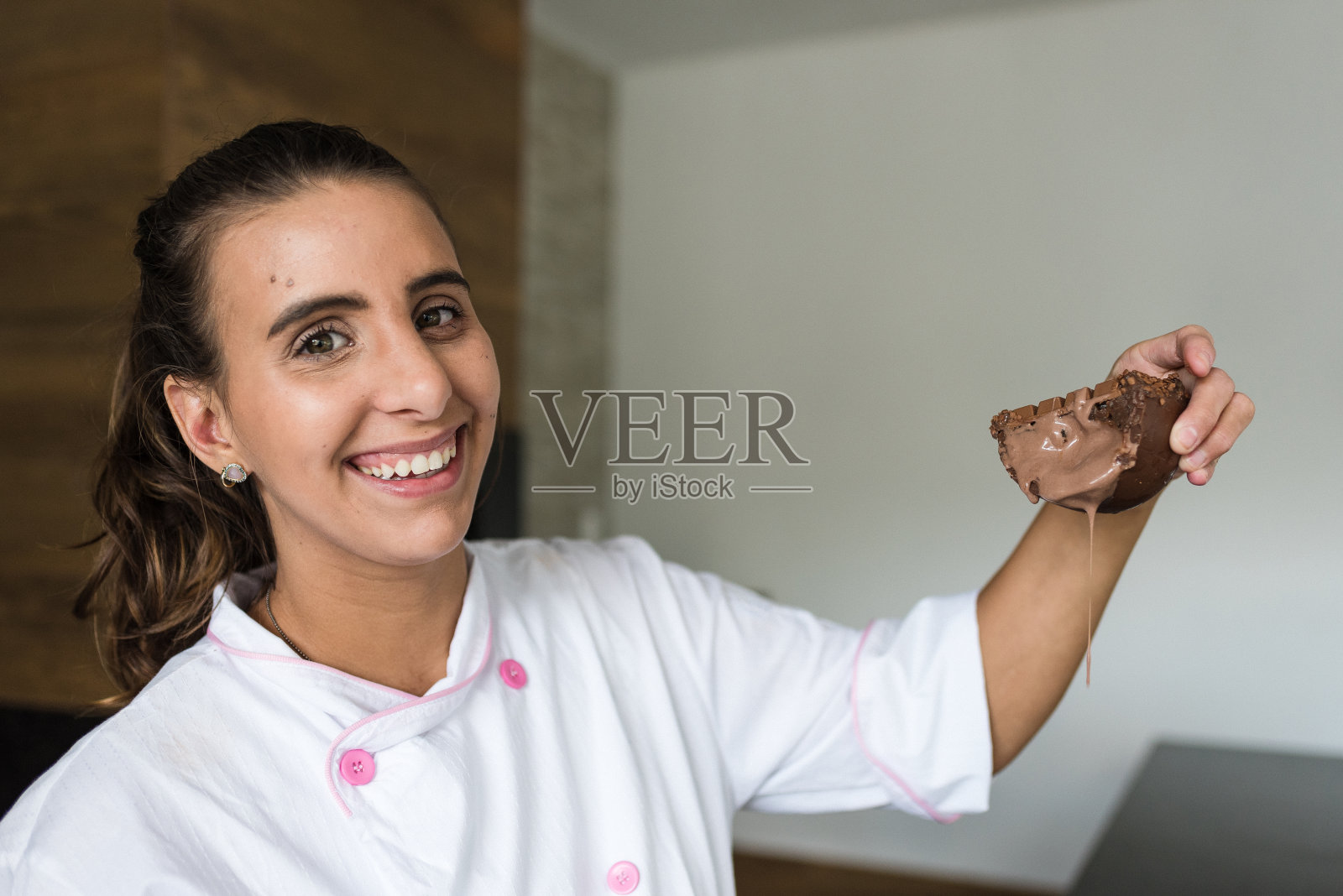 厨师拿着一块带馅的巧克力照片摄影图片