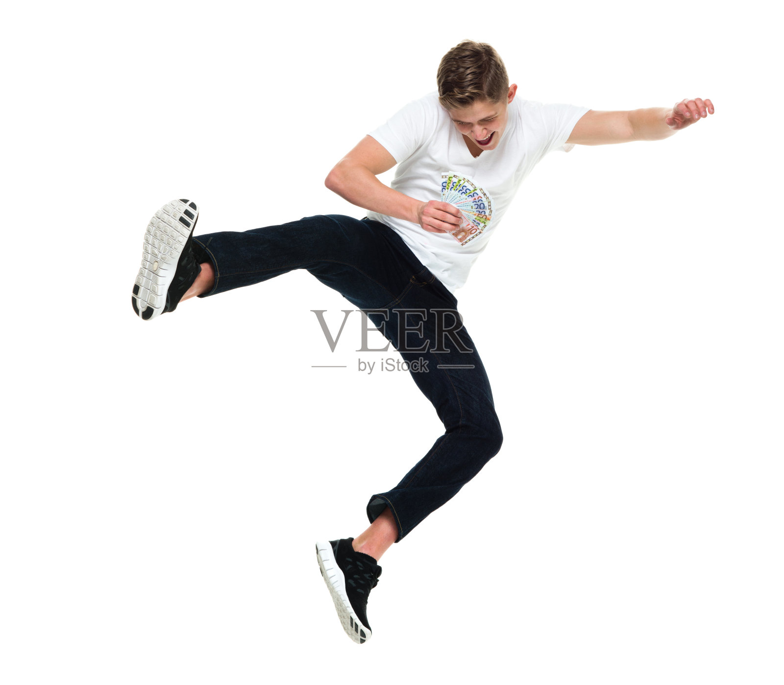 穿着运动鞋拿着欧盟货币在白色背景前跳跃的白人青少年男孩照片摄影图片