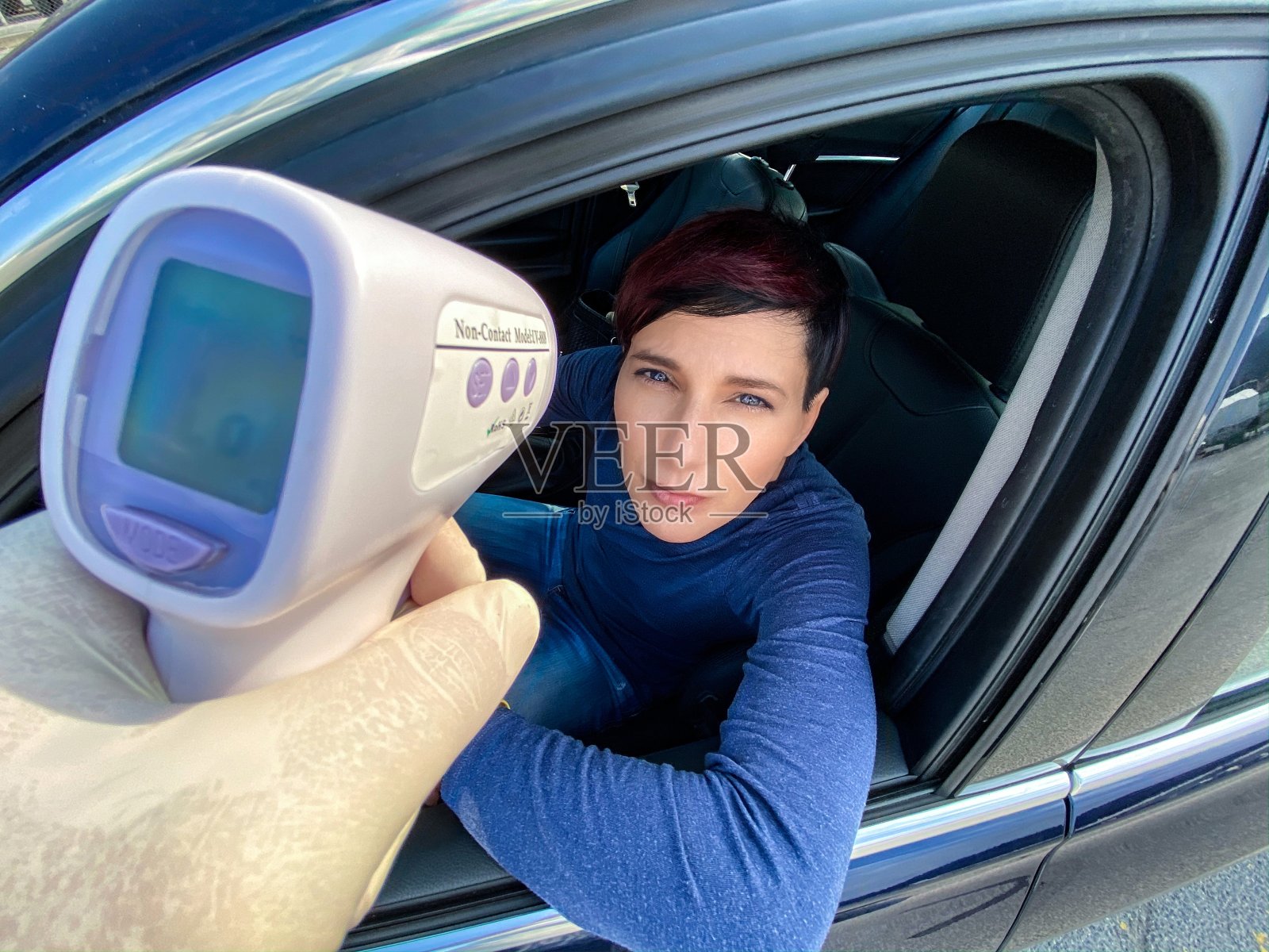 新冠疫情期间，在国际边境管制处用红外测温仪检测体温的女人照片摄影图片