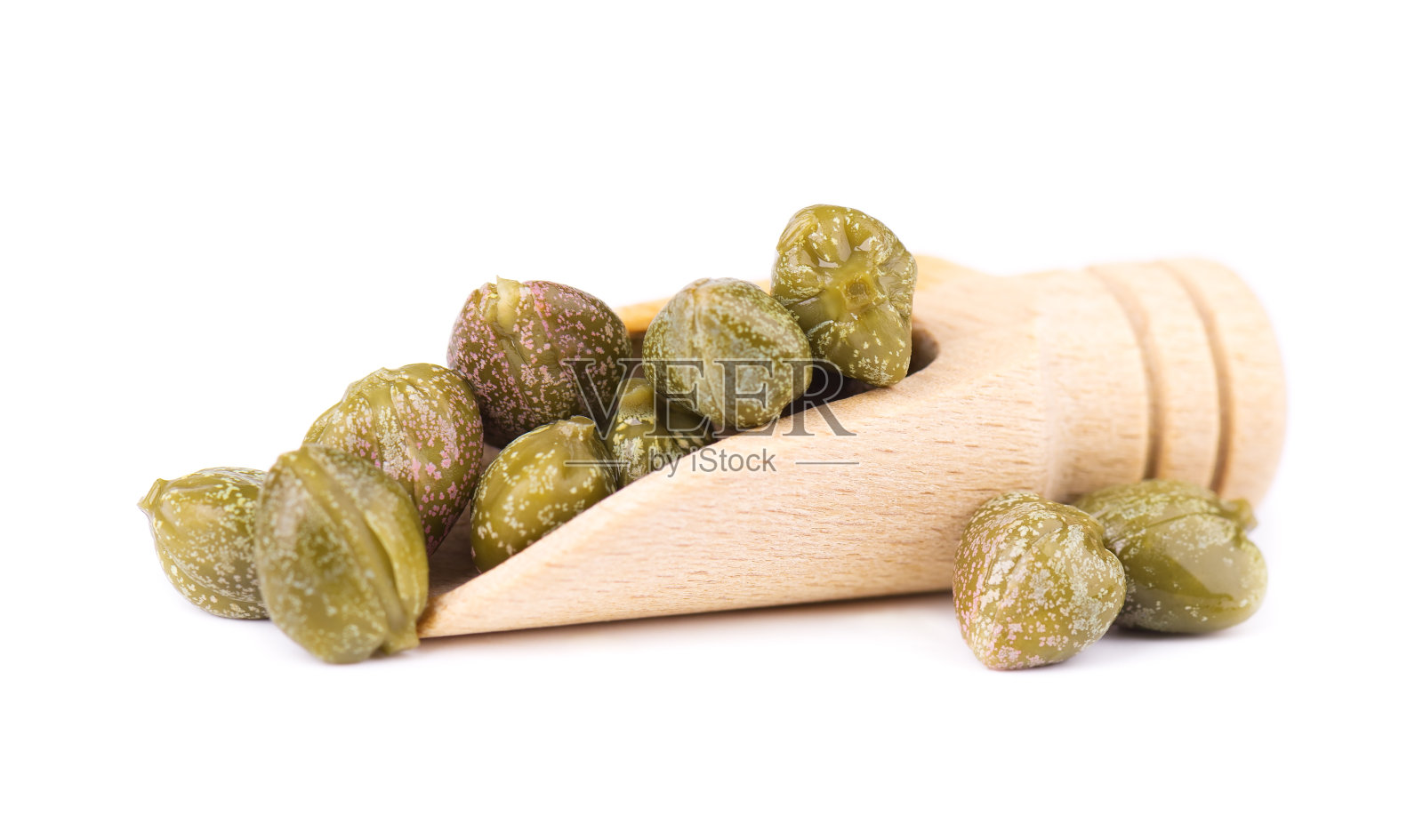 木勺里的刺山柑，孤立在白色背景上。腌酸豆。酸豆罐头。照片摄影图片