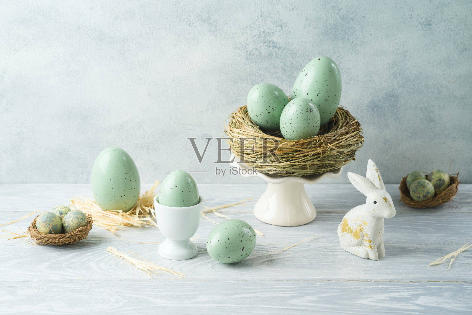 复活节节日用复活节彩蛋、兔子和鸟窝装饰在木桌上照片摄影图片