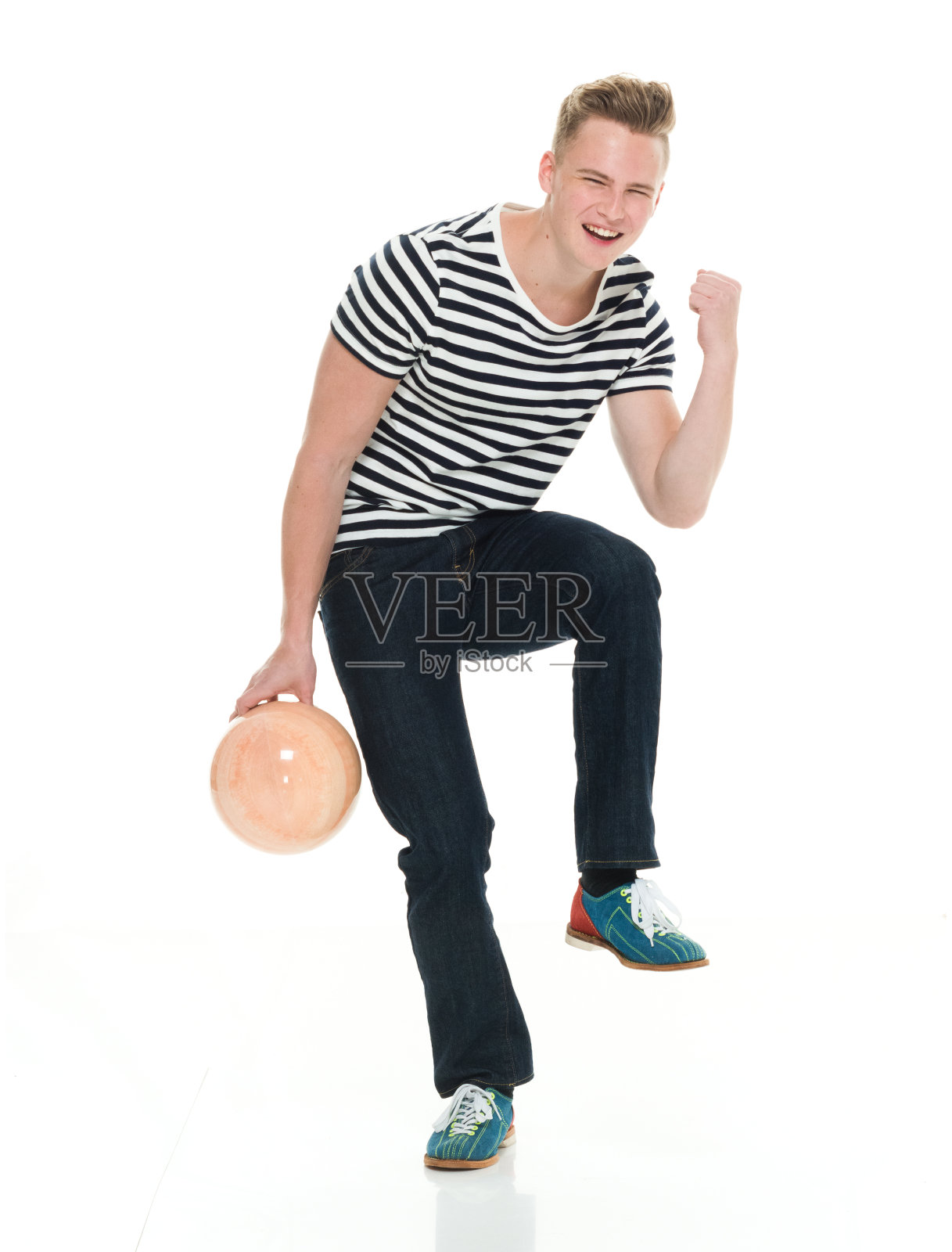 站在白色背景前，穿着牛仔裤、拿着运动球的白人男子照片摄影图片