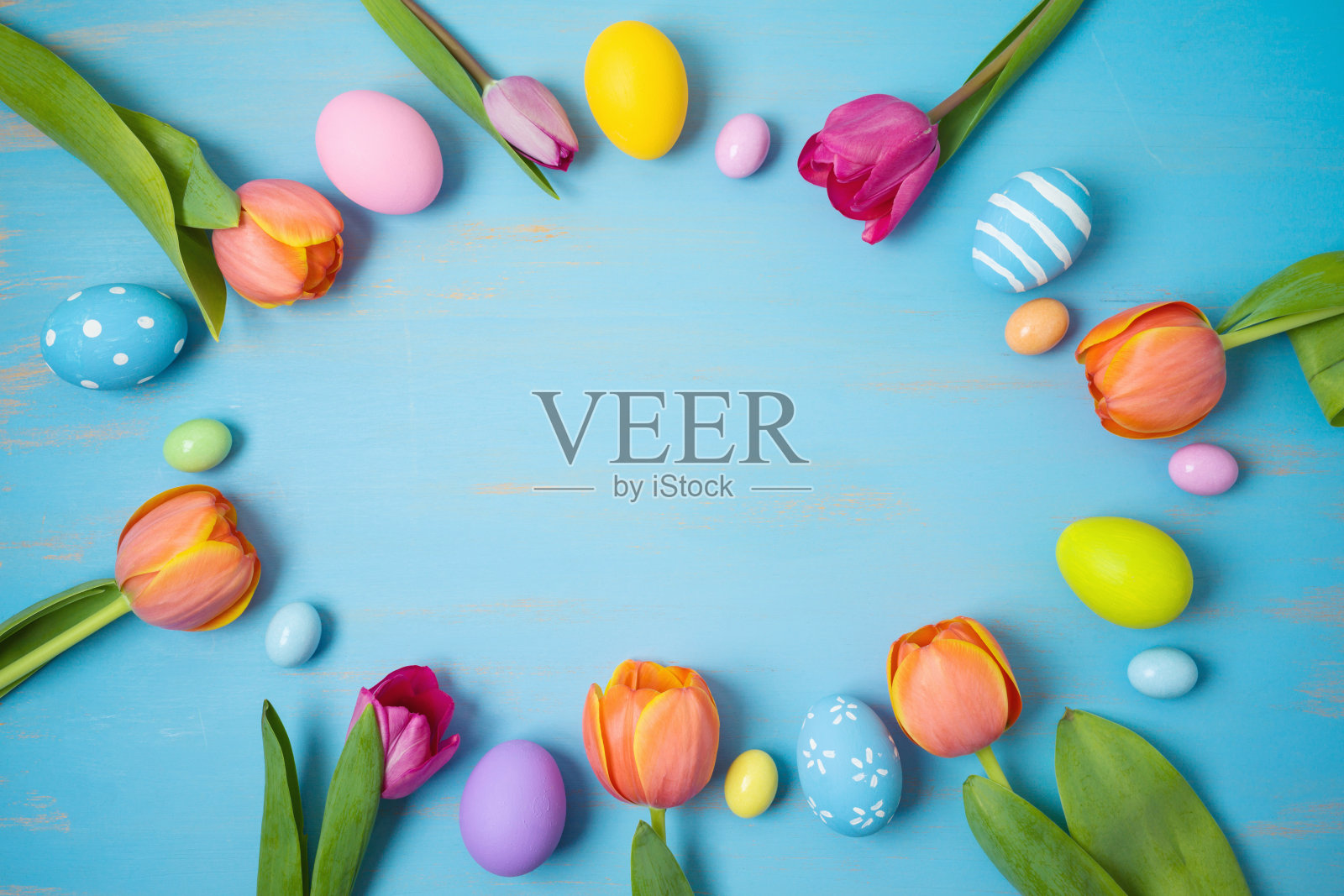 复活节节日背景与复活节蛋和郁金香花在木制桌子上。从上面俯视照片摄影图片