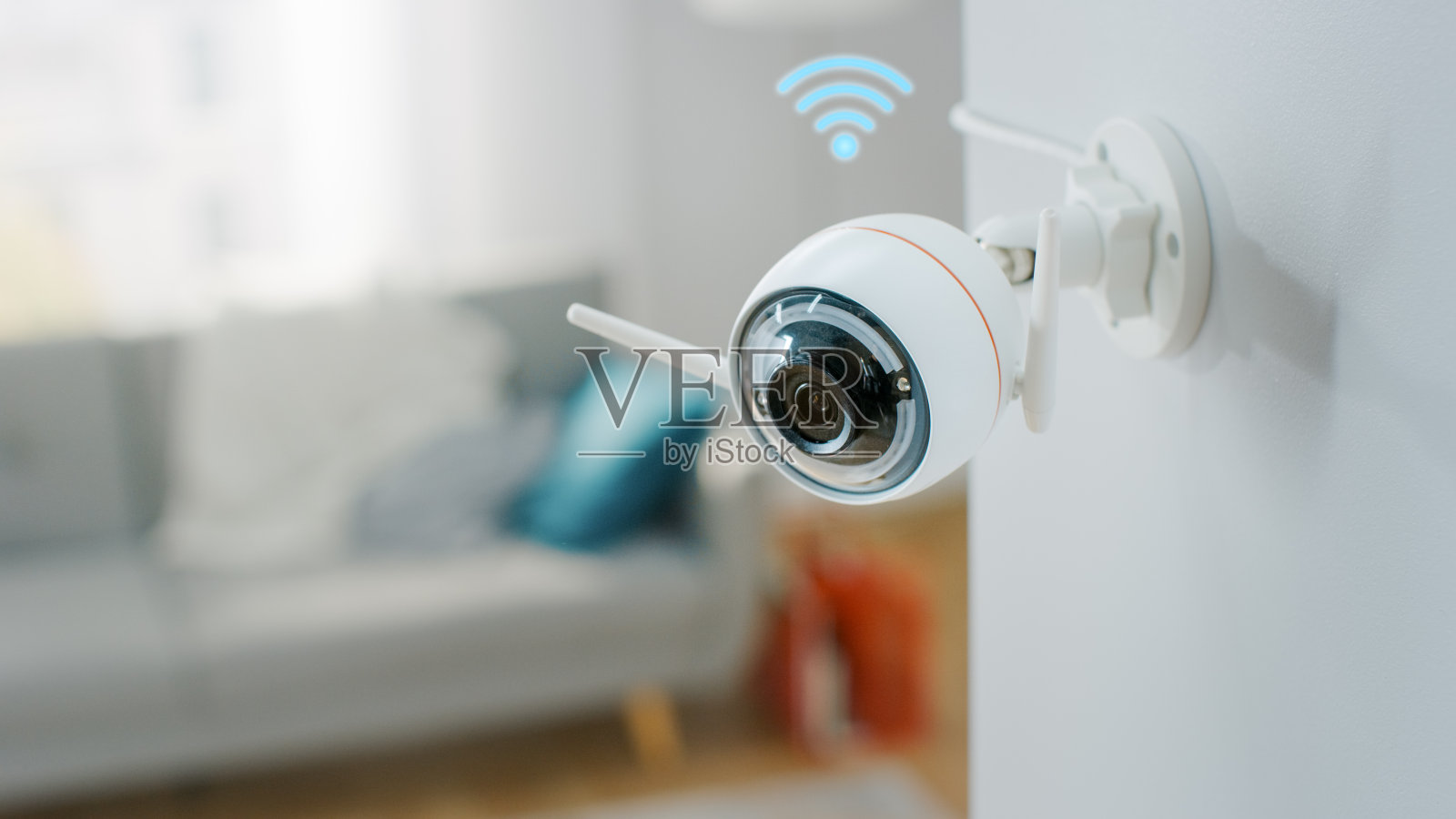 近距离物体拍摄的现代Wi-Fi监控摄像头与两个天线在一个舒适的公寓的白墙上有Wi-Fi图标。照片摄影图片