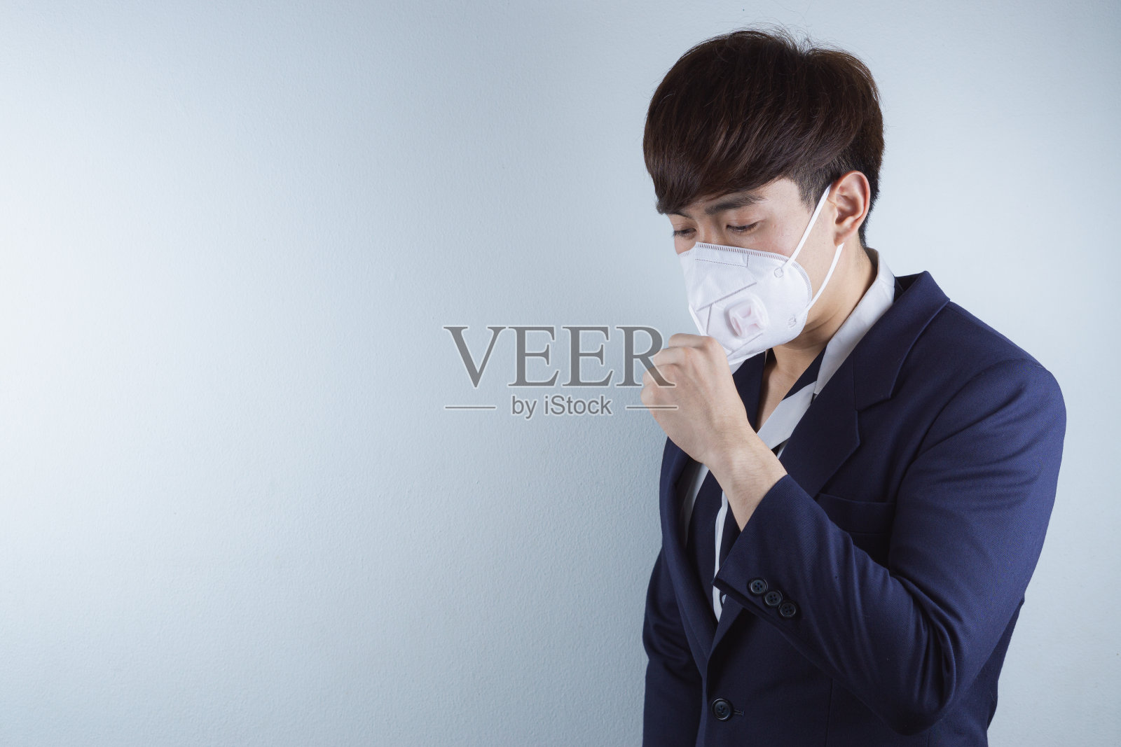 因冠状病毒和PM2.5而咳嗽的商务男人。冠状病毒和空气污染PM2.5概念。照片摄影图片