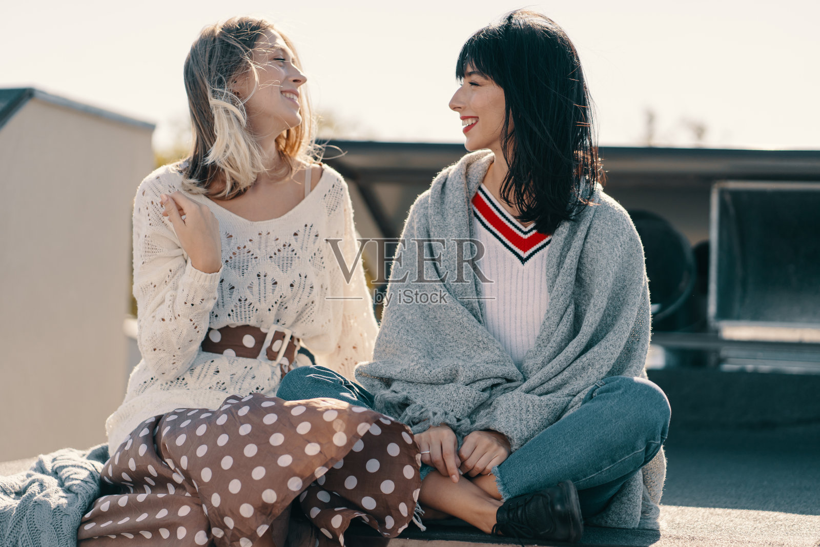 在城市屋顶放松的两位迷人女孩照片摄影图片