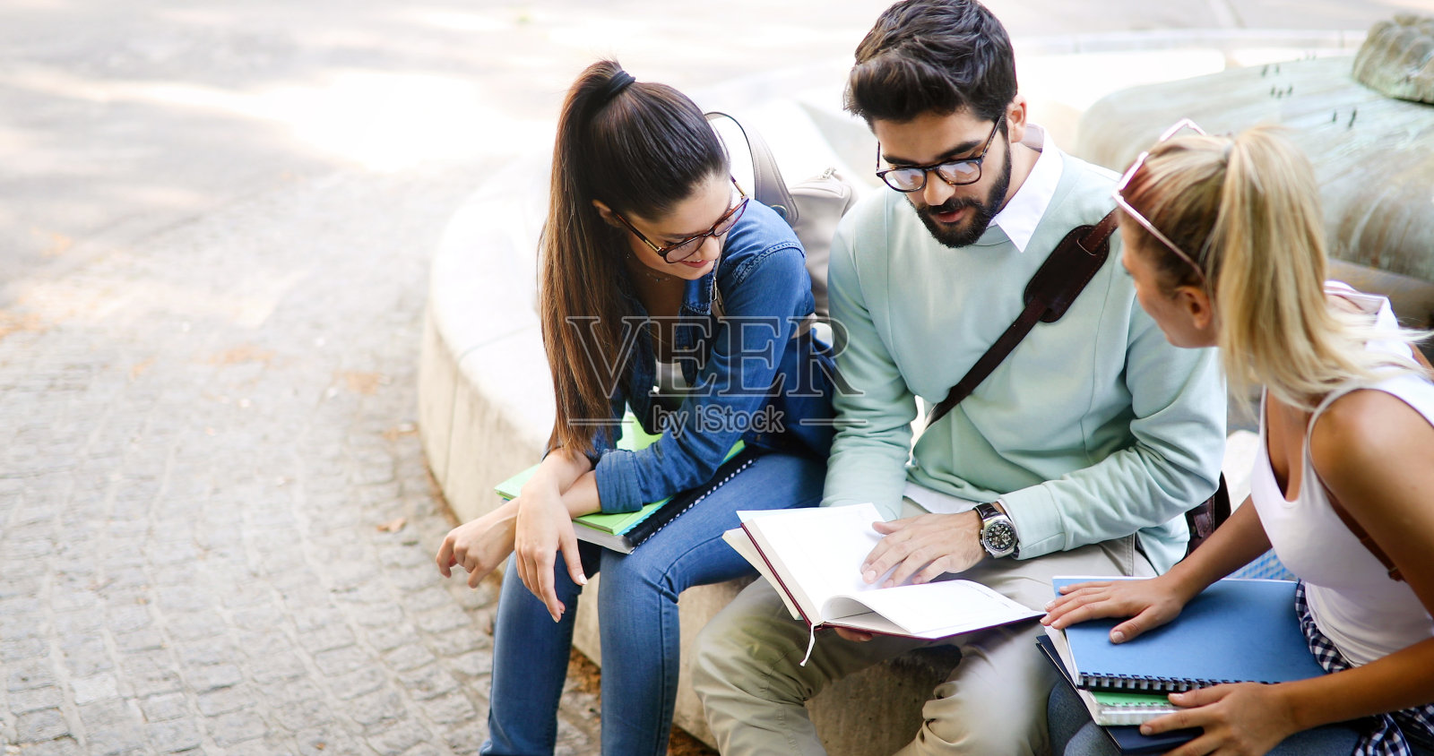 快乐年轻的大学生朋友们在大学里用书学习照片摄影图片