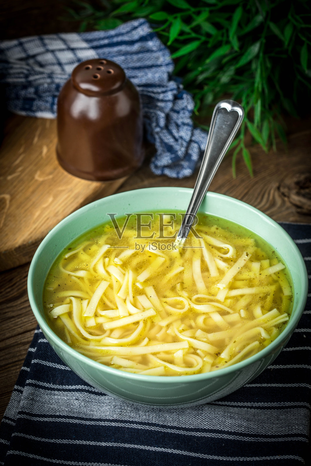 鸡汤——用碗盛鸡汤。照片摄影图片