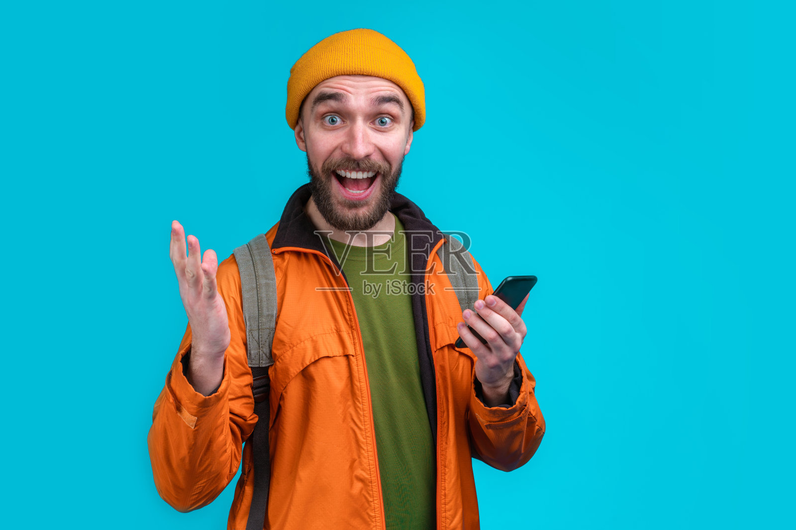 休闲装微笑男游客的半身工作室肖像（蓝色背景，带背包）照片摄影图片