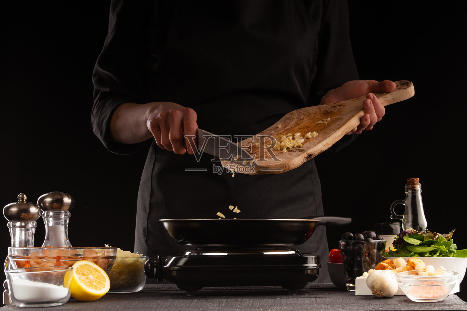 厨师将蒜炸成虾汁。海鲜和东方食谱。照片摄影图片