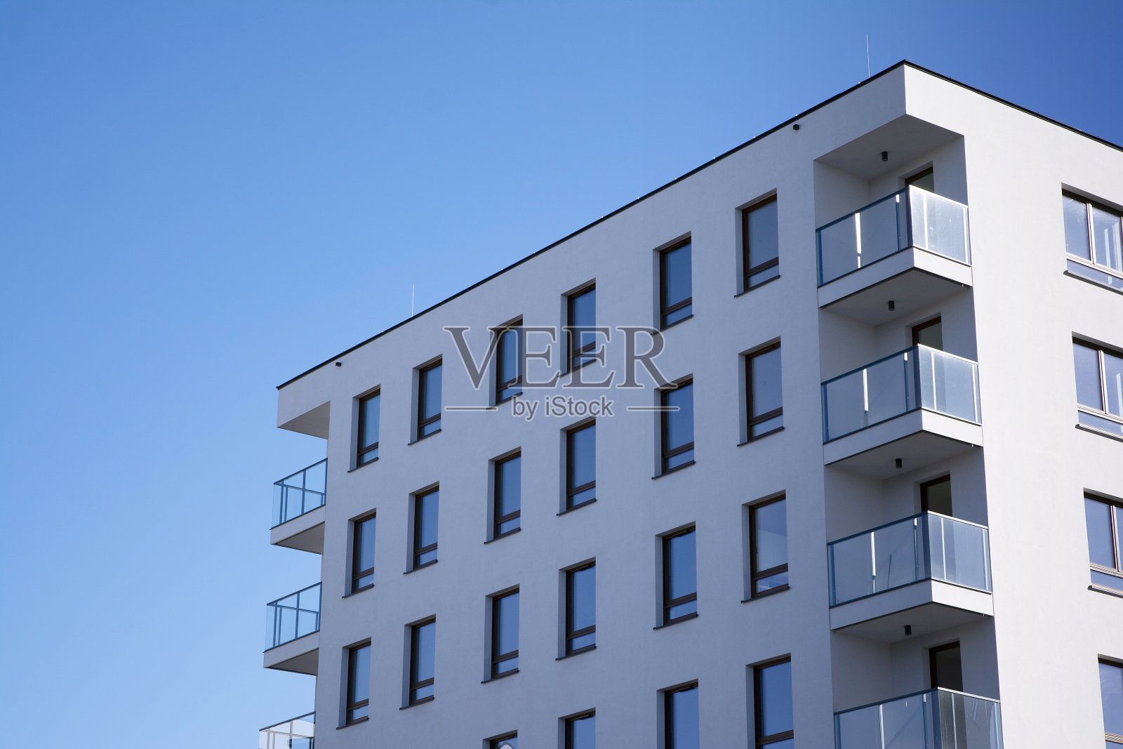 新公寓大楼的外部在蓝色多云的天空背景。照片摄影图片