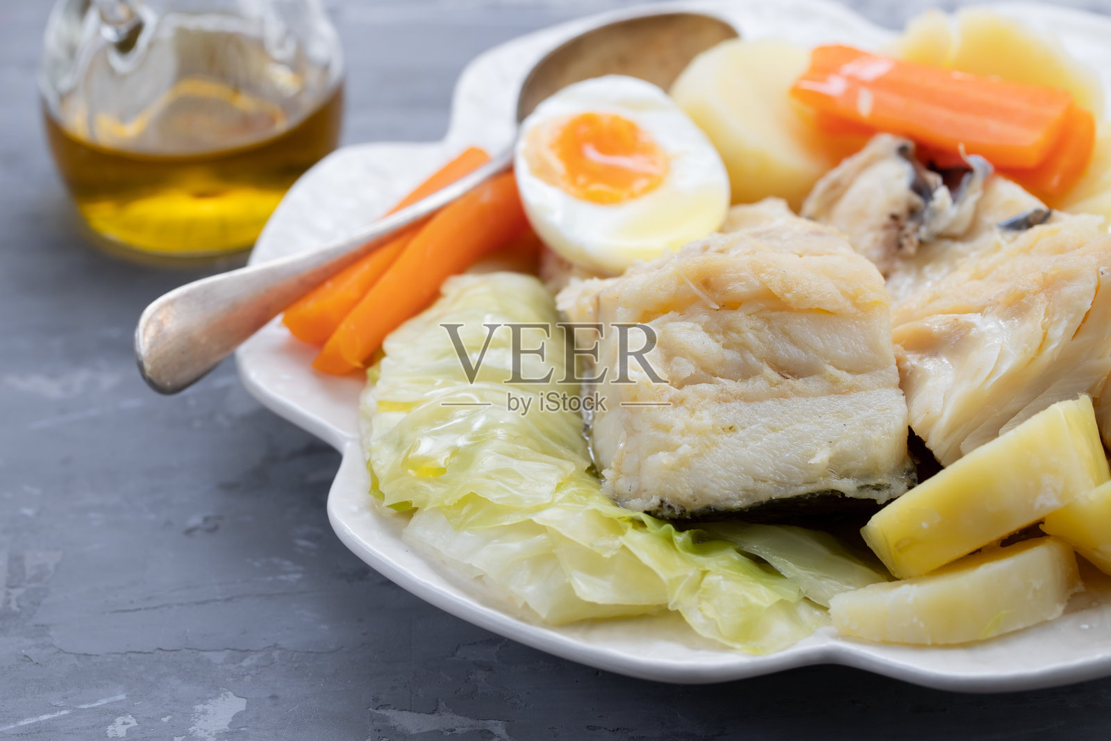 水煮鱼，蔬菜和水煮鸡蛋放在白盘子里照片摄影图片