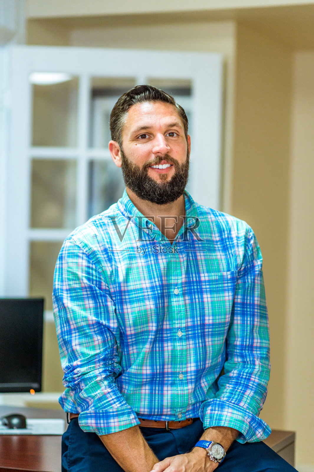 一个穿着商务装的人坐在办公室的桌子上照片摄影图片