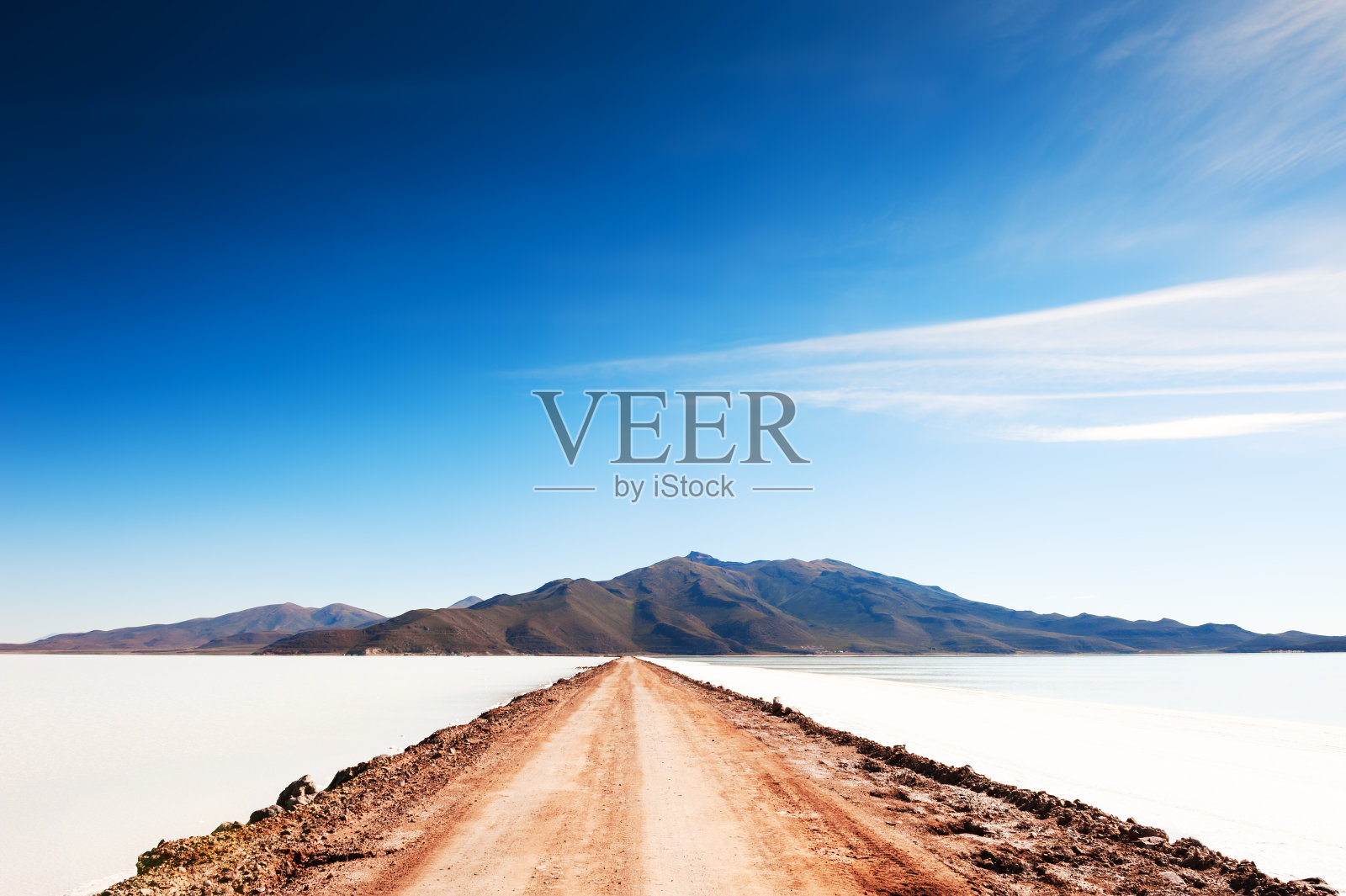 在玻利维亚的乌尤尼盐沼上通往火山的道路。照片摄影图片