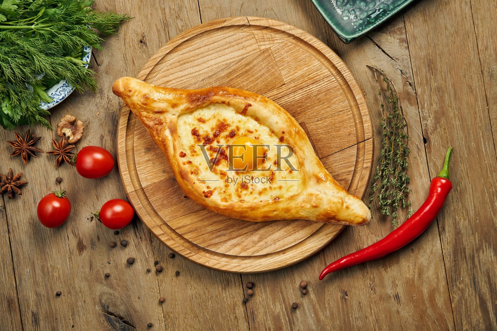 俯视图美味的传统阿贾利安哈切布里-打开烤派与融化的盐奶酪(苏鲁古尼)和蛋黄在木制托盘上。传统的格鲁吉亚食品照片摄影图片