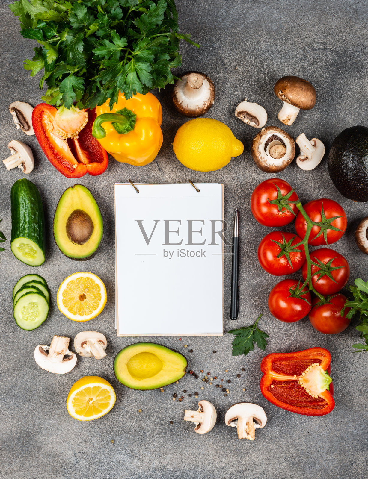 用不同的蔬菜和配料烹调美味佳肴。桌上放着一本写食谱的书，周围摆满了食物。文本复制空间照片摄影图片