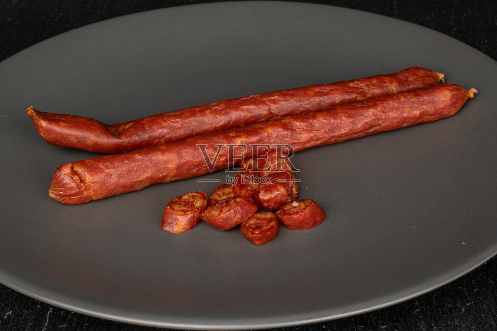 灰石头上的熏辣香肠照片摄影图片