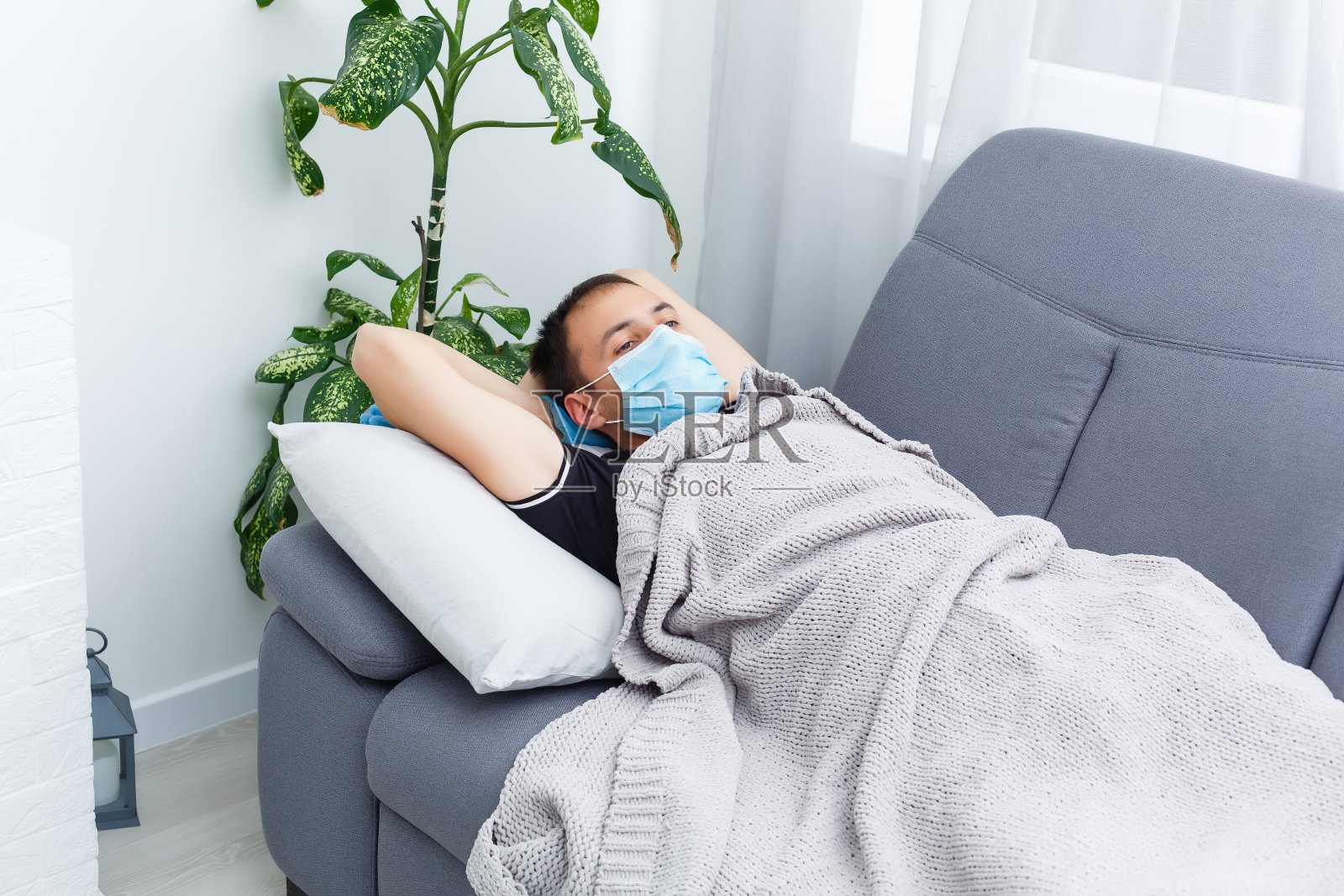 戴着口罩的生病男子头像。新冠病毒概念。保护您的健康。照片摄影图片