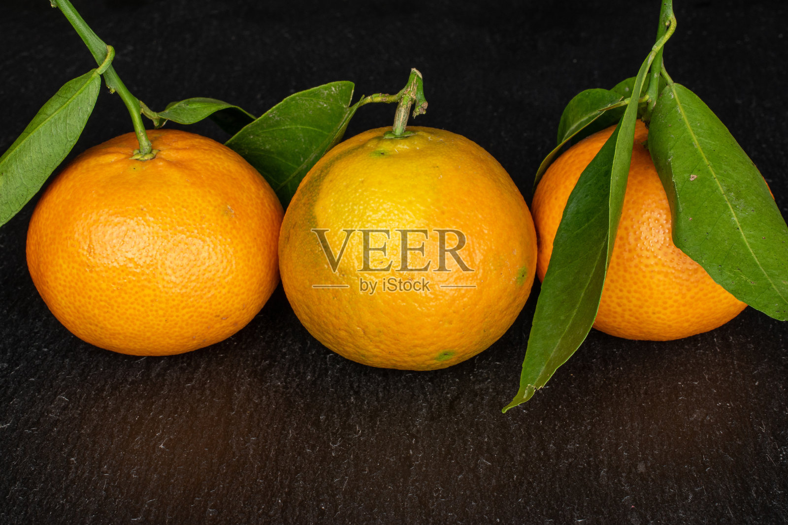 新鲜的橘子，灰色的石头照片摄影图片