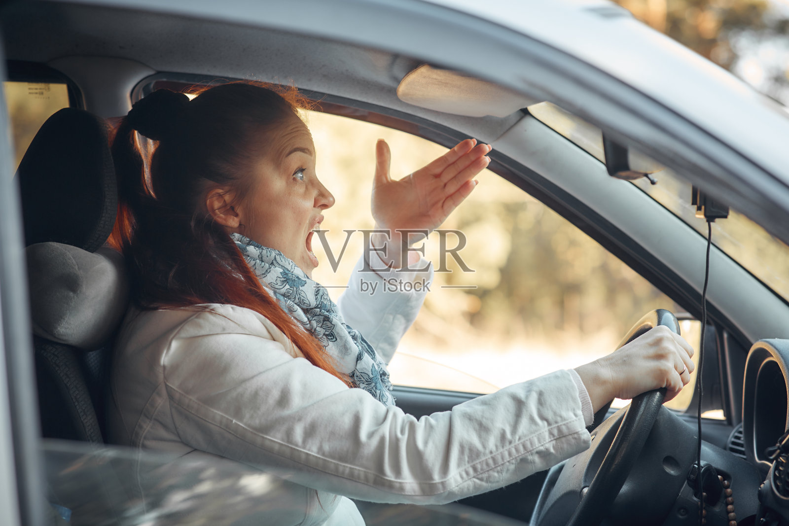 中年妇女坐在车里抱怨交通状况——车停在乡村路边照片摄影图片