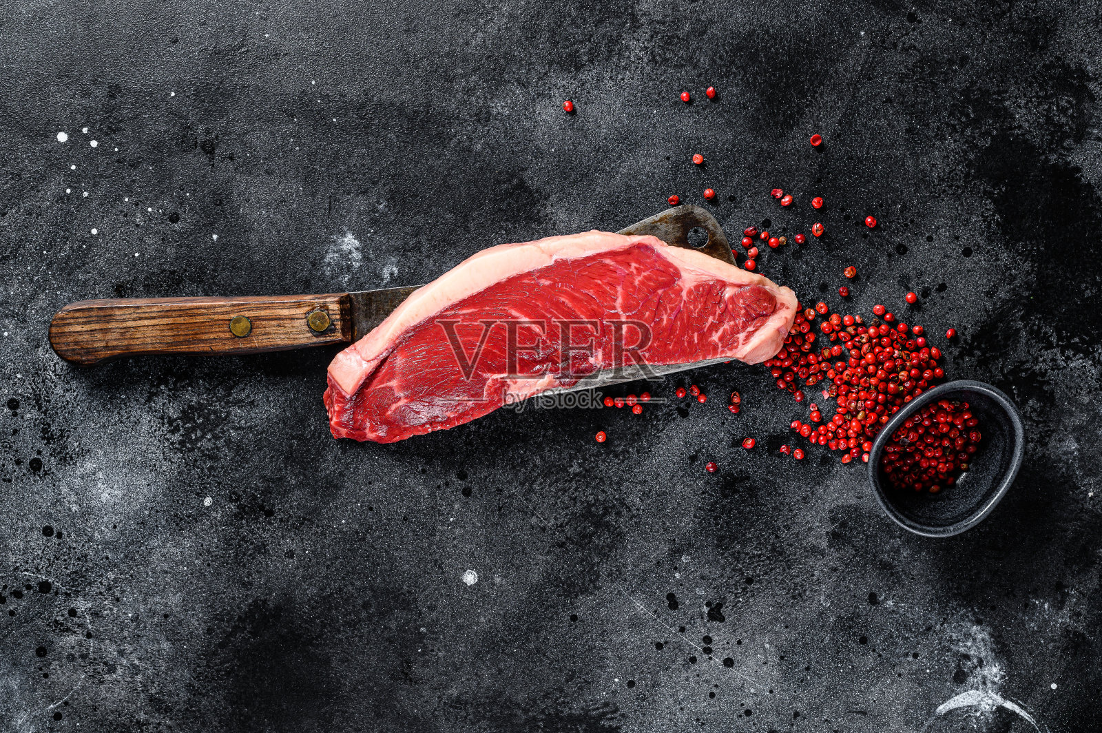 切肉刀上的生腰肉排。黑安格斯牛肉。黑色背景。俯视图照片摄影图片