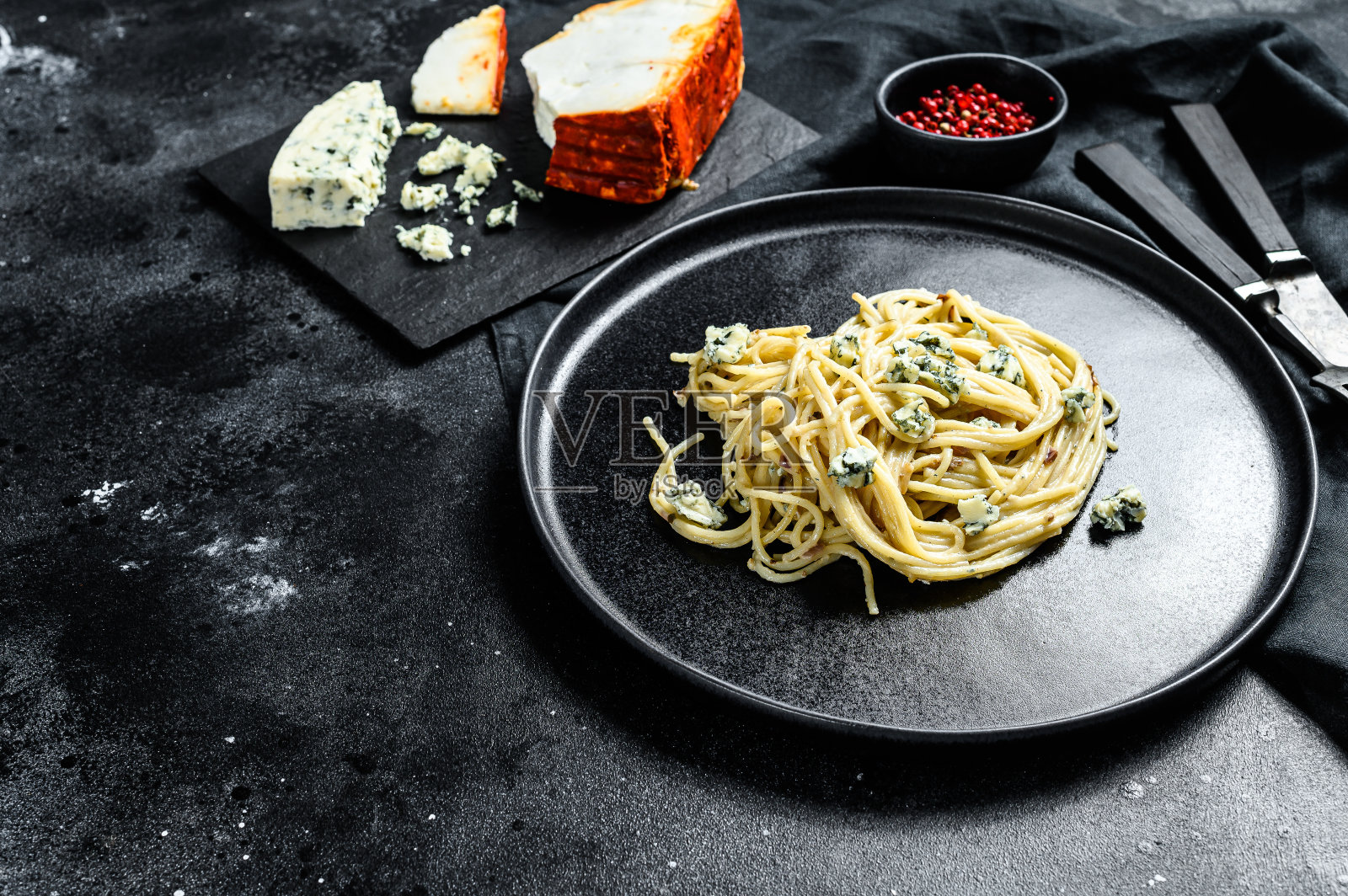 意大利面酱配奶油蓝芝士酱和核桃。意大利人自制的食物。这是一道美味的素食菜肴。黑色背景。前视图。本空间照片摄影图片