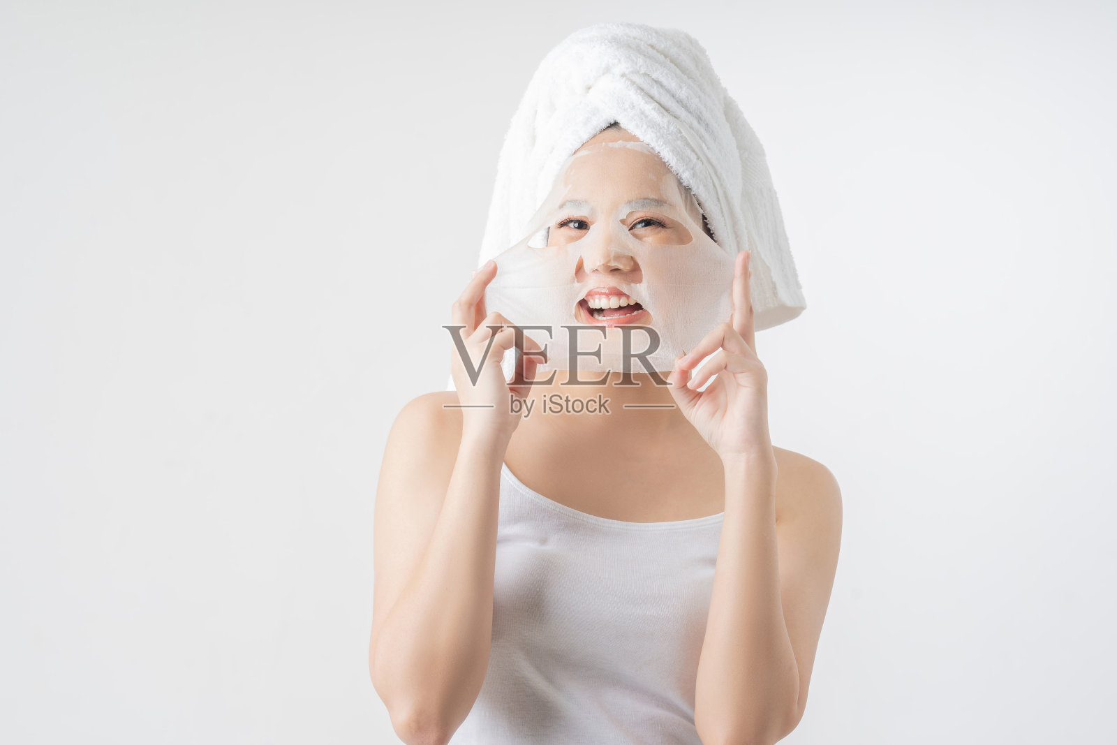 亚洲女人是面膜。她既高兴又惊讶。照片摄影图片