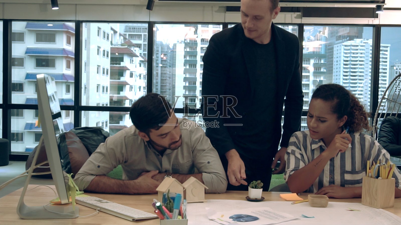 创意商务人士在办公桌旁交谈。照片摄影图片